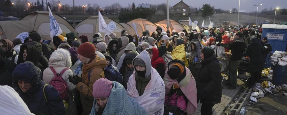 Une foule de réfugiés attendent de pouvoir franchir la frontière entre Ukraine et Pologne, le 7 mars 2022 à Medyka. [Keystone - Markus Schreiber]