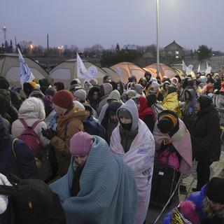 Une foule de réfugiés attendent de pouvoir franchir la frontière entre Ukraine et Pologne, le 7 mars 2022 à Medyka. [Keystone - Markus Schreiber]