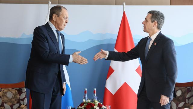 Poignée de mains entre le ministre russe des Affaires étrangères Sergeï Lavrov et le président de la Confédération Ignazio Cassis. [EPA/Keystone - Ministère russe des Affaires étrangères]