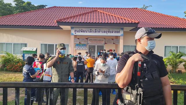 Des policiers devant les bâtiments dans lequel un ancien policier armé d'un fusil et d'un couteau a tué jeudi 35 personnes, dont 22 enfants d'une crèche en Thaïlande. [Keystone - EPA/RUAMKATANYU FOUNDATION]