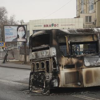 Une vue d'un bus brûlé après des affrontements, dans une rue d'Almaty, au Kazakhstan, vendredi 7 janvier 2022. [NUR.KZ via AP/KEYSTONE - Vladimir Tretyakov]