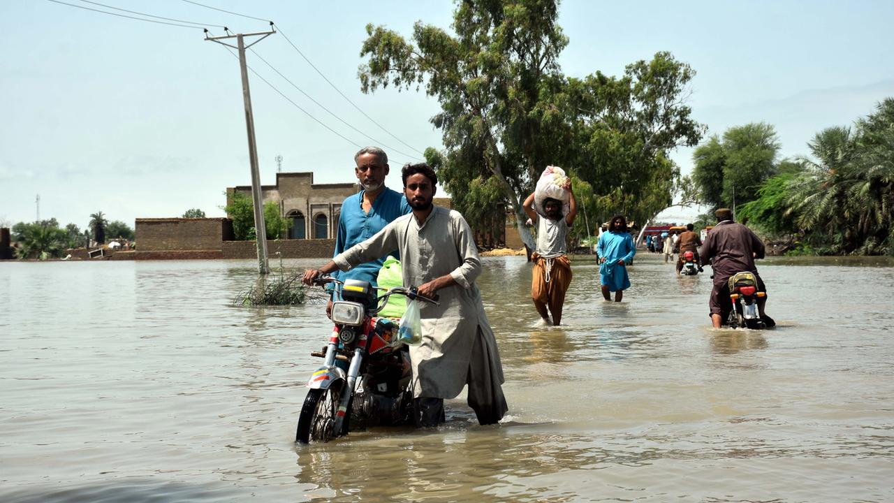 Des personnes pataugent dans une zone inondée suite à de fortes pluies dans le district de Kamber Shahdadkot, province de Sindh, Pakistan, le 29 août 2022 [EPA - Waqar Hussain]
