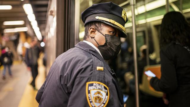 Un officier de la police de New York observe un wagon de métro à la station "36th street". [Keystone - John Minchillo]