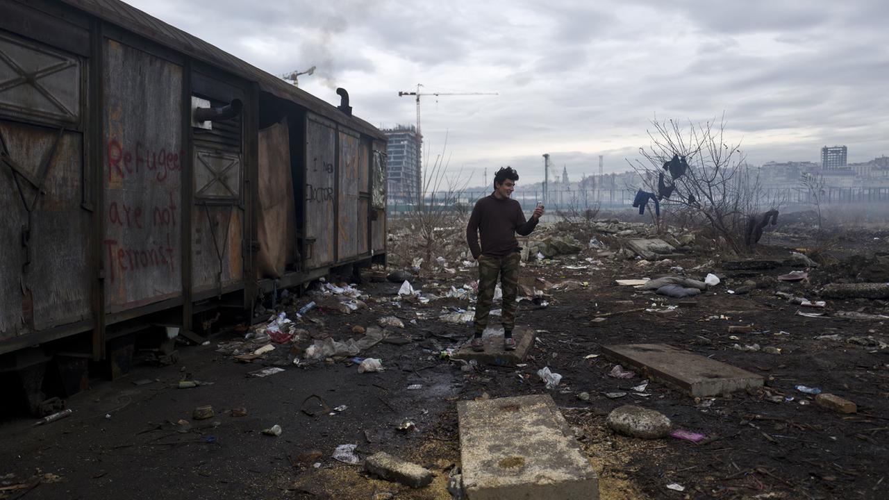 Un réfugié afghan se rase la barbe à l'extérieur d'un entrepôt abandonné où lui et d'autres migrants se réfugient à Belgrade, en Serbie [AP Photo - Muhammed Muheisen]