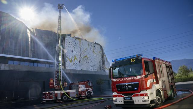 Les pompiers du Service d'incendie et de secours (SIS) interviennent sur un incendie dans une zone industrielle de Meyrin Satigny, le 17 avril 2022 près de Genève. [Keystone - Martial Trezzini]