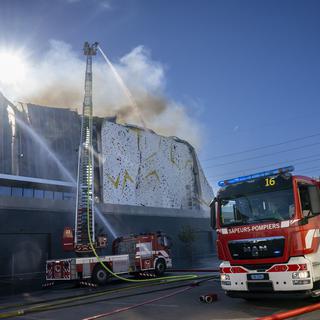 Les pompiers du Service d'incendie et de secours (SIS) interviennent sur un incendie dans une zone industrielle de Meyrin Satigny, le 17 avril 2022 près de Genève. [Keystone - Martial Trezzini]