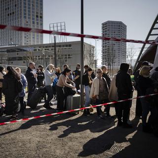Des réfugiés ukrainiens font la queue et attendent d'être enregistrés devant le centre fédéral d'asile de Zurich, le dimanche 13 mars 2022 à Zurich. [KEYSTONE - Michael Buholzer]