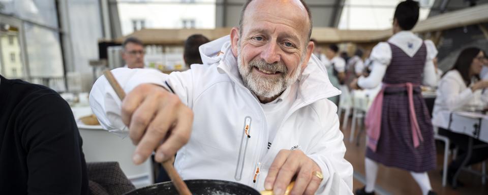 L'organisateur du Festival de la fondue Dominique Buman touille une fondue lors de la première édition. [Keystone - Anthony Anex]