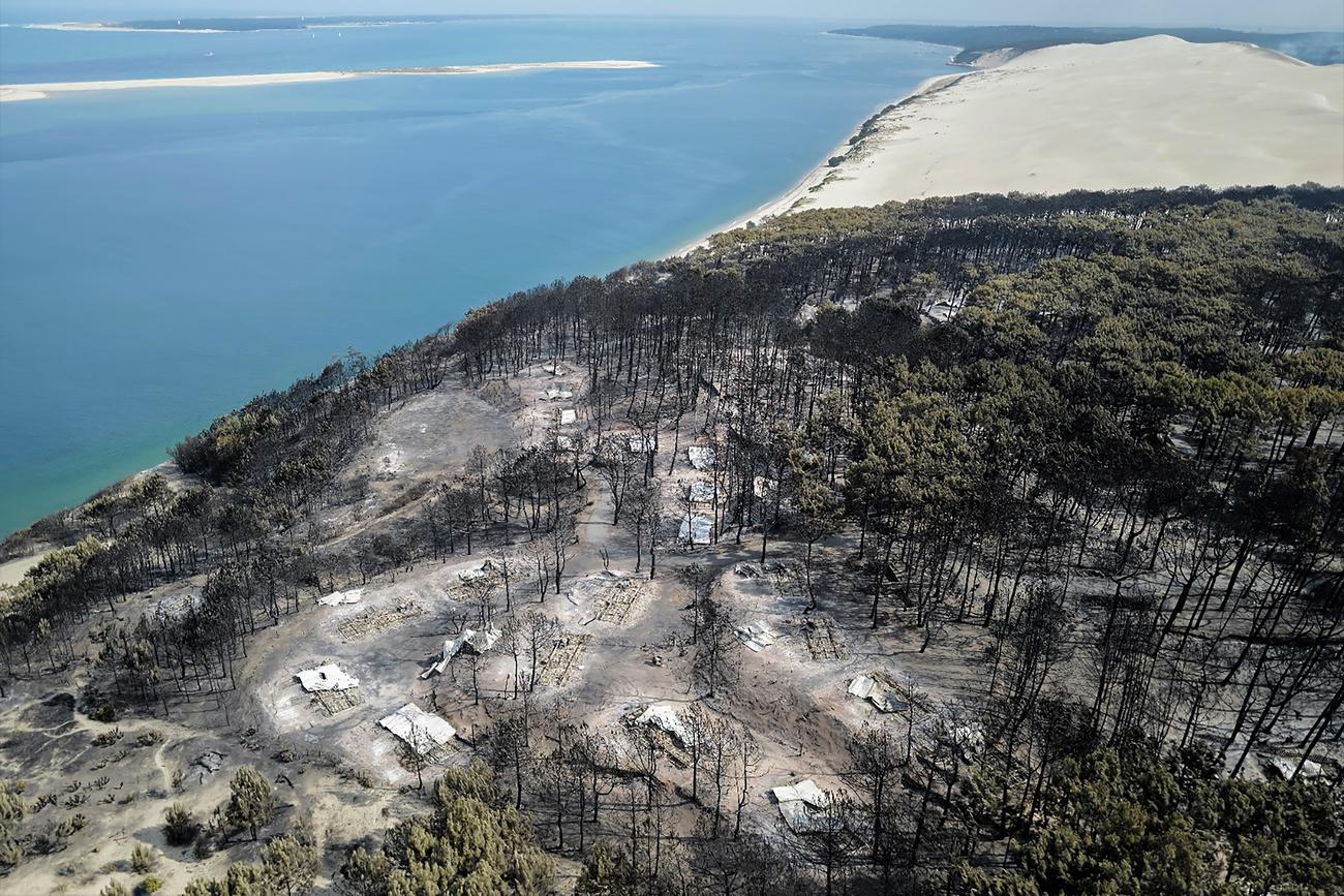 Une image aérienne de la désolation laissée par le feu de forêts qui s'est arrêté à la dune du Pyla, en Gironde. [Keystone - SDIS 33 via AP]