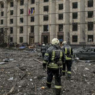 Des secouristes sur le site d'une attaque russe contre le palais municipal de la ville de Kharkiv en Ukraine, le 1er mars 2022. [AP/Keystone - Pavel Dorogoy]