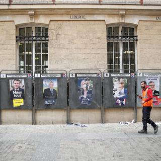 Un homme passe devant les affiches des candidats à l'élection présidentielle française, à Paris, en France, le 29 mars 2022. [EPA/KEYSTONE - Mohammed Badra]