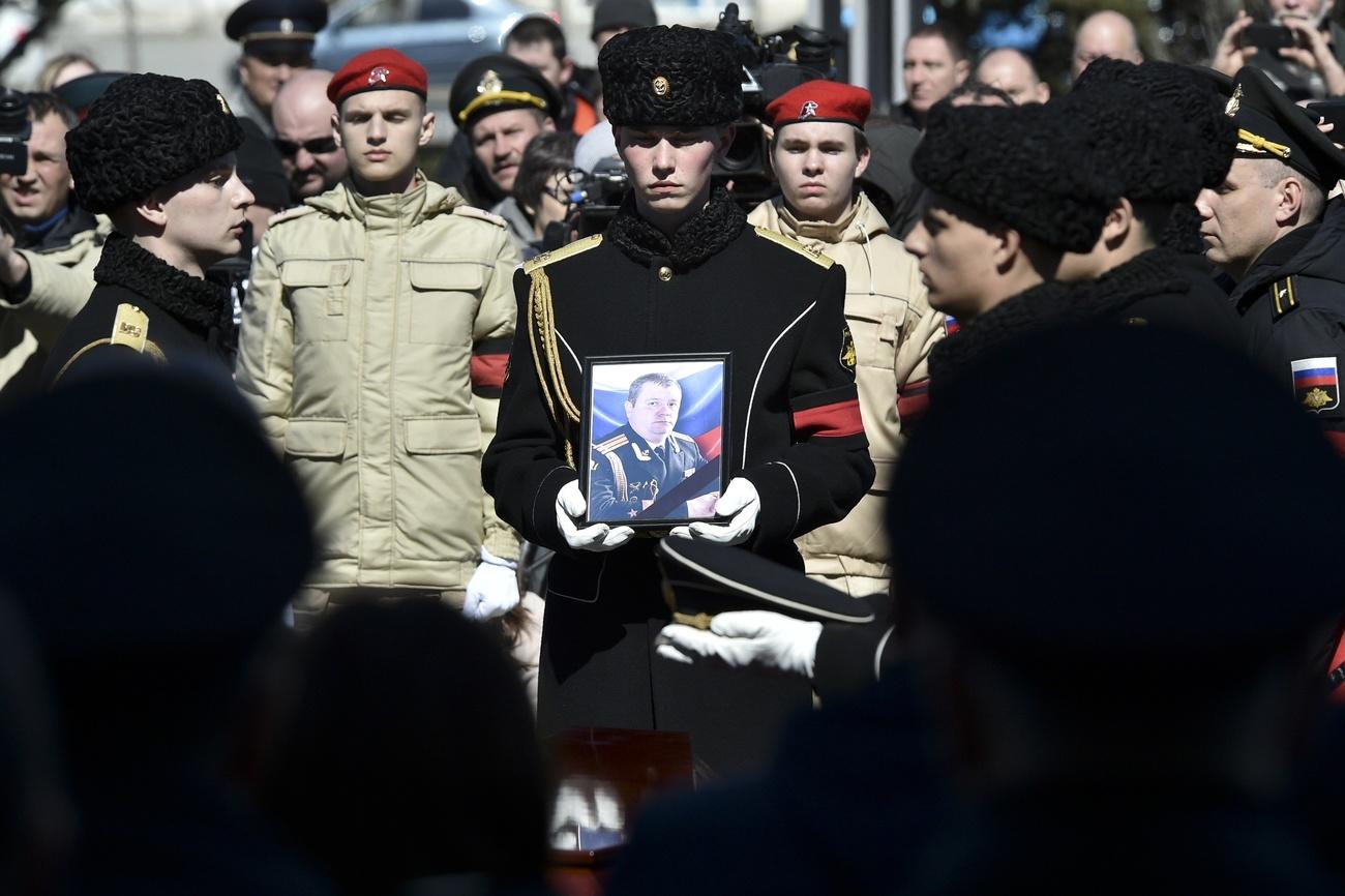 Un militaire porte la photo du Capitaine Andrei Paliy, commandant adjoint de la flotte russe de la mer Noire, lors d'une cérémonie d'adieu à Sébastopol, en Crimée, mercredi 23 mars 2022. [AP Photo/KEYSTONE]