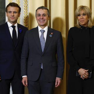 Le président Emmanuel Macron, sa femme et le président Ignazio Cassis à Paris. [AP/Keystone - Gonzalo Fuentes]