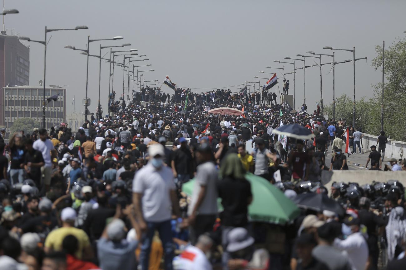 Des manifestants se rassemblent sur un pont menant à la Zone verte de Bagdad, en Irak, samedi 30 juillet 2022. [KEYSTONE - Anmar Khalil / AP Photo]
