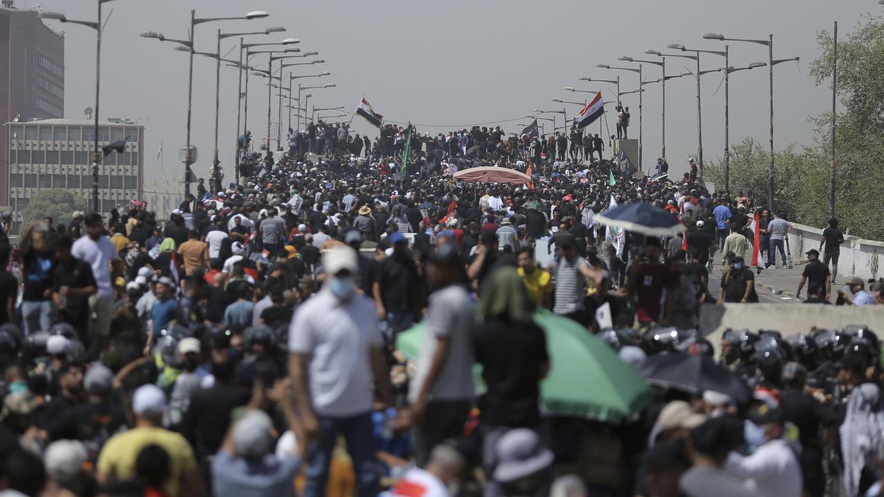 Des manifestants se rassemblent sur un pont menant à la Zone verte de Bagdad, en Irak, samedi 30 juillet 2022. [KEYSTONE - Anmar Khalil / AP Photo]