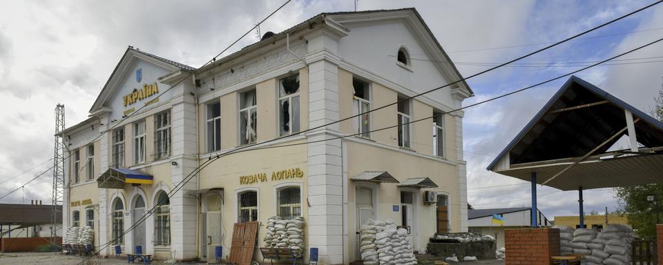 Un homme marche devant la gare de Kozacha Lopan, dans le nord-ouest de l'Ukraine, le 3 octobre 2022. [Keystone - EPA/OLEG PETRASYUK]