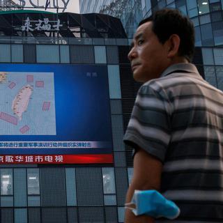 FILE PHOTO: A man stands in front of a screen showing a CCTV news broadcast, featuring a map of locations around Taiwan where Chinese People's Liberation Army (PLA) was to conduct military exercises and training activities including live-fire drills, at a shopping center in Beijing, China, August 3, 2022. REUTERS/Thomas Peter/File Photo [reuters - Thomas Peter]