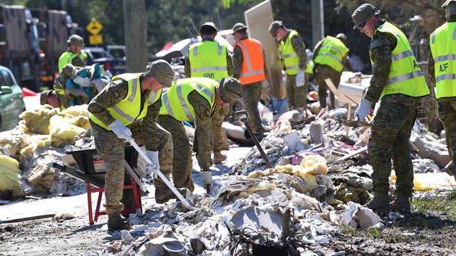 Membres de l'ADF (Australian Defence Force) nettoyant des propriétés affectées par les inondations à Goodna en Australie. [EPA - Darren England - Keystone]