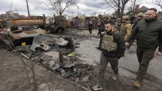 Une photo distribuée par le service de presse présidentiel ukrainien montre le président ukrainien Volodymyr Zelensky (C) marchant dans une rue où se trouvent des machines russes endommagées, dans la région de Kiev (Bucha) reprise par l'armée ukrainienne, Ukraine, le 4 avril 2022. [EPA/KEYSTONE]