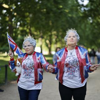 Des fans royaux portant des masques de la Reine Elizabeth se préparent à la cérémonie de la parade du jubilé de platine de la Reine Elizabeth à Londres, Grande-Bretagne, le 2 juin 2022. [EPA/KEYSTONE - Tolga Akmen]
