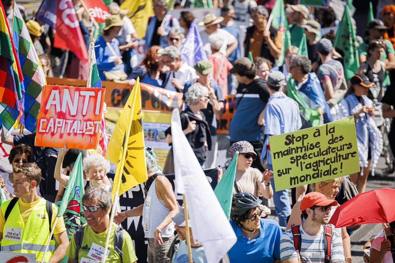 Des personnes défilent à Genève lors d'une manifestation contre l'Organisation mondiale du commerce (OMC) à la veille de sa 12e Conférence ministérielle. [KEYSTONE - Valentin Flauraud]