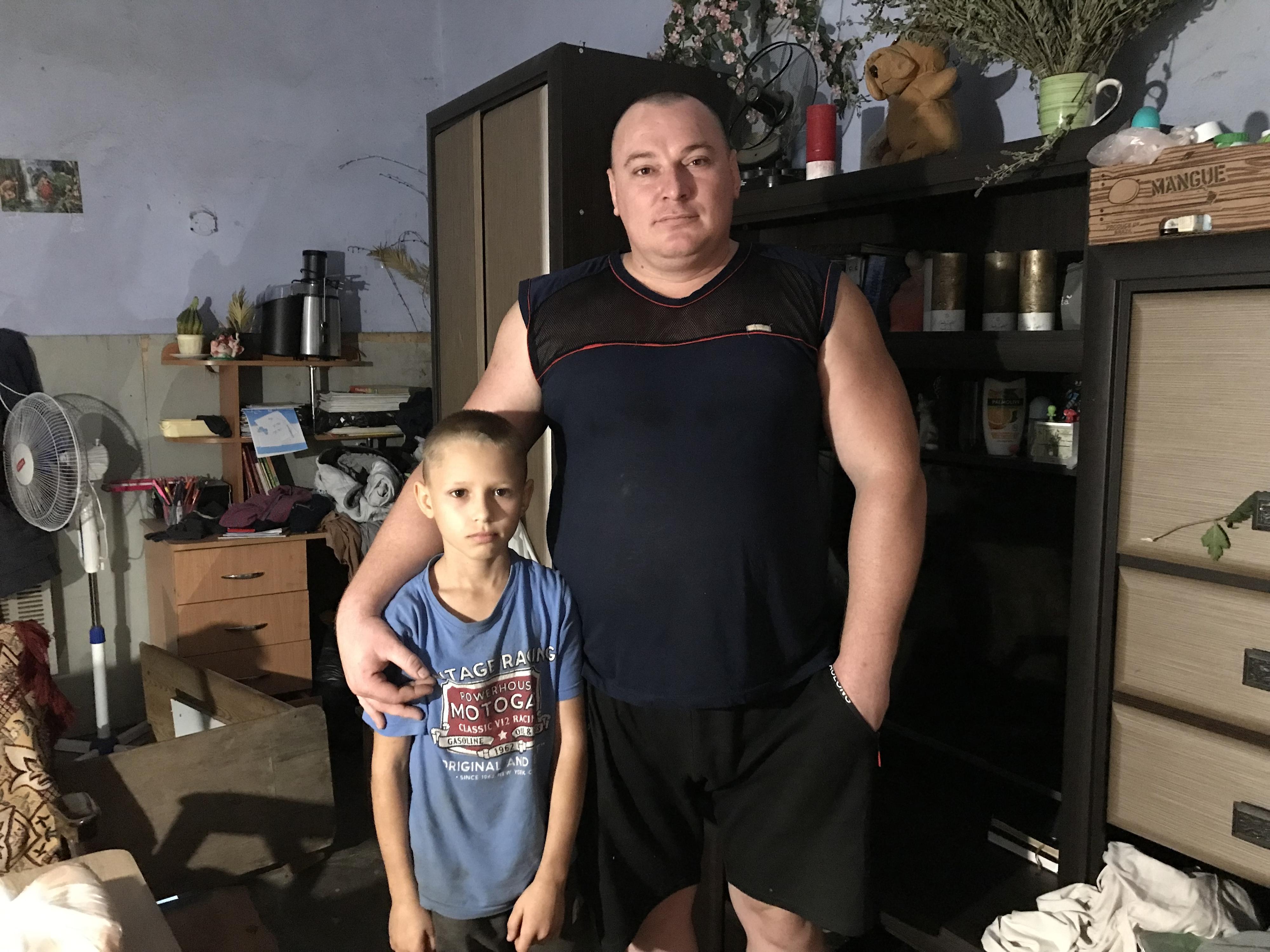 Igor et son fils dans un garage de Mykolaïv, en Ukraine. Ils s'y sont réfugiés avec leur famille après avoir fui leur village, désormais sur la ligne de front sud. [RTS - Maurine Mercier]