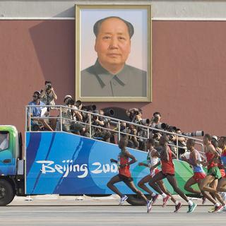 Samuel Kamau Wansiru du Kenya mène le peloton du marathon alors que les concurrents passent devant un portrait géant du président Mao sur la place Tiananmen, lors de l'épreuve du marathon masculin, le dernier jour des Jeux olympiques 2008 de Pékin, en Chine, le 24 août 2008. [EPA/KEYSTONE - Ahmad Yusni]