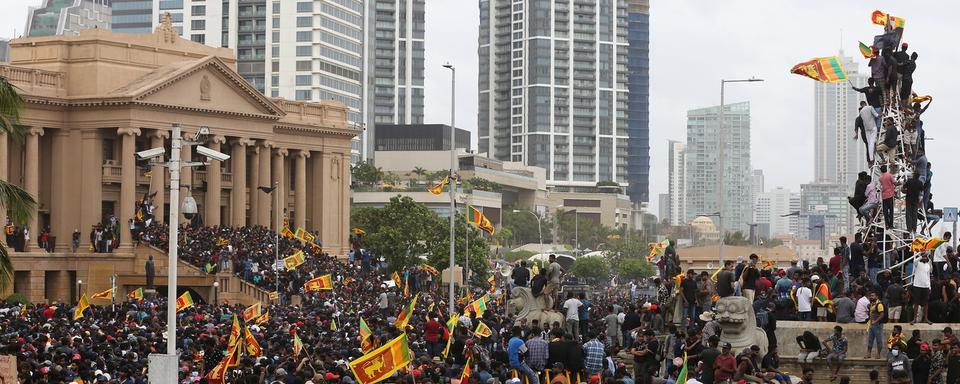 De nombreux manifestants ont pénétré dans le palais présidentiel à Colombo, un bâtiment datant de l'époque coloniale, situé en bord de mer et symbole du pouvoir au Sri Lanka. [Keystone - EPA/CHAMILA KARUNARATHNE]