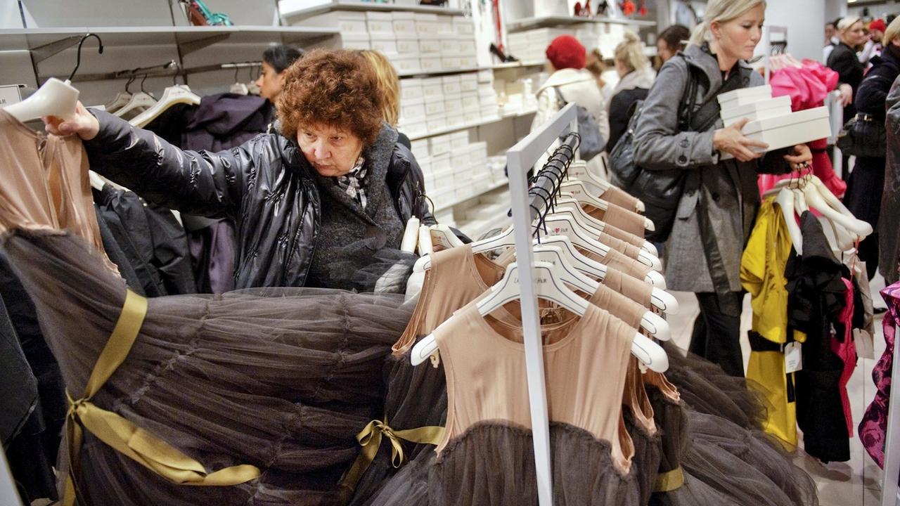 A woman tries a dress in a Stockholm store as H&M rolls out a collection by Lanvin, Tuesday, Nov. 23, 2010. Lanvin is the next high-fashion house to become a partner of fast-fashion retailer H&M. The joint collection, featuring womenswear and menswear, went on sale Nov. 20 in North America and then to the rest of the world Tuesday. (AP Photo/Jessica Gow) SWEDEN OUT [AP - Jessica Gow]