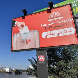 Un panneau encourageant les gens à voter aux élections nationales tunisiennes prévues le 17 décembre 2022 affiché le long d'une route à Tunis, en Tunisie. [AFP - Fethi Belaid]