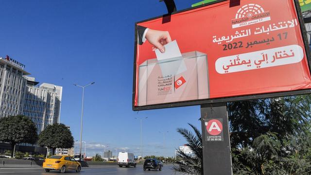 Un panneau encourageant les gens à voter aux élections nationales tunisiennes prévues le 17 décembre 2022 affiché le long d'une route à Tunis, en Tunisie. [AFP - Fethi Belaid]