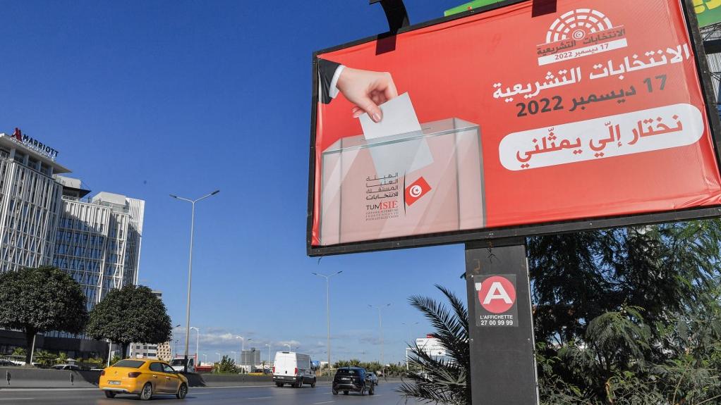 Un panneau encourageant les gens à voter aux élections nationales tunisiennes prévues le 17 décembre 2022 affiché le long d'une route à Tunis, en Tunisie. [AFP - Fethi Belaid]