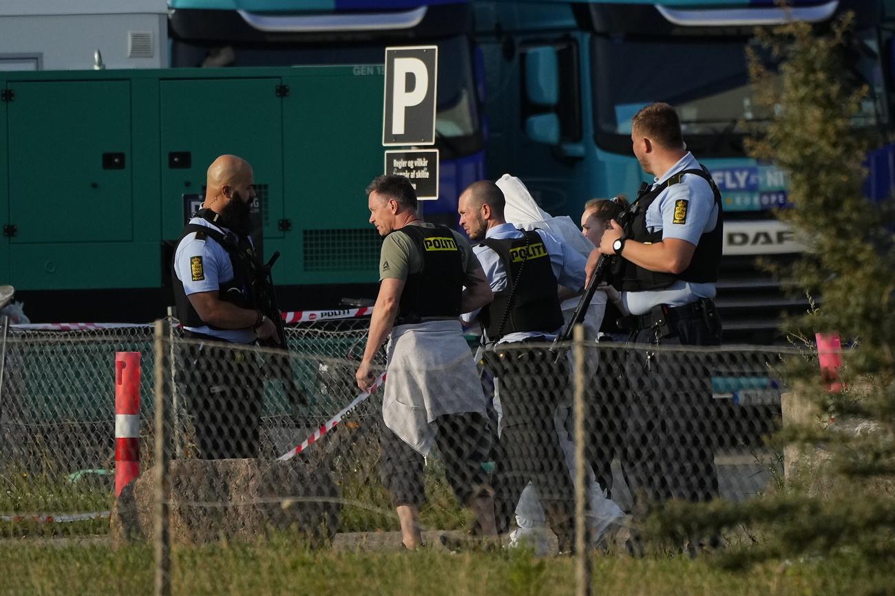 Une personne est emmenée par la police, près du centre commercial Fields, après une fusillade à Copenhague, au Danemark, le dimanche 3 juillet 2022. [KEYSTONE - Claus Bech / Ritzau Scanpix / AP]