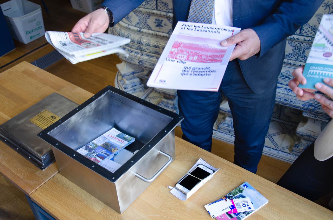 Placement des objets dans la capsule temporelle destinée aux générations futures. [Ville de Lausanne - Mathilde Imesch]