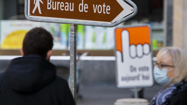 Panneau devant un bureau de vote dans le canton de Neuchâtel [Keystone - Jean-Christophe Bott]