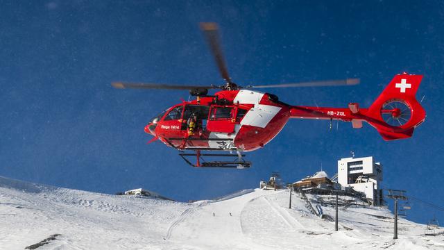 Un hélicoptère de la Rega lors d'un exercice au glacier des Diablerets. [Keystone - Jean-Christophe Bott]