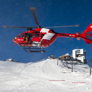 Un hélicoptère de la Rega lors d'un exercice au glacier des Diablerets. [Keystone - Jean-Christophe Bott]