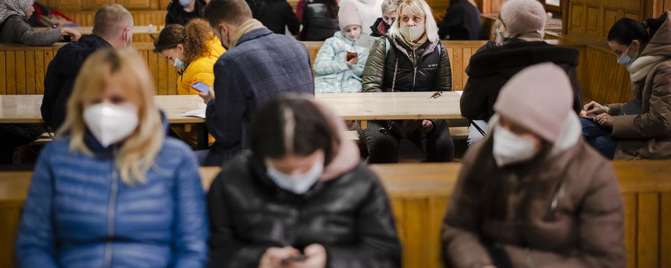 Des réfugiés ukrainiens attendent au centre d'accueil pour réfugiés ukrainiens de l'ancienne caserne militaire de Zurich, le mardi 15 mars 2022 à Zurich [Keystone - Michael Buholzer]