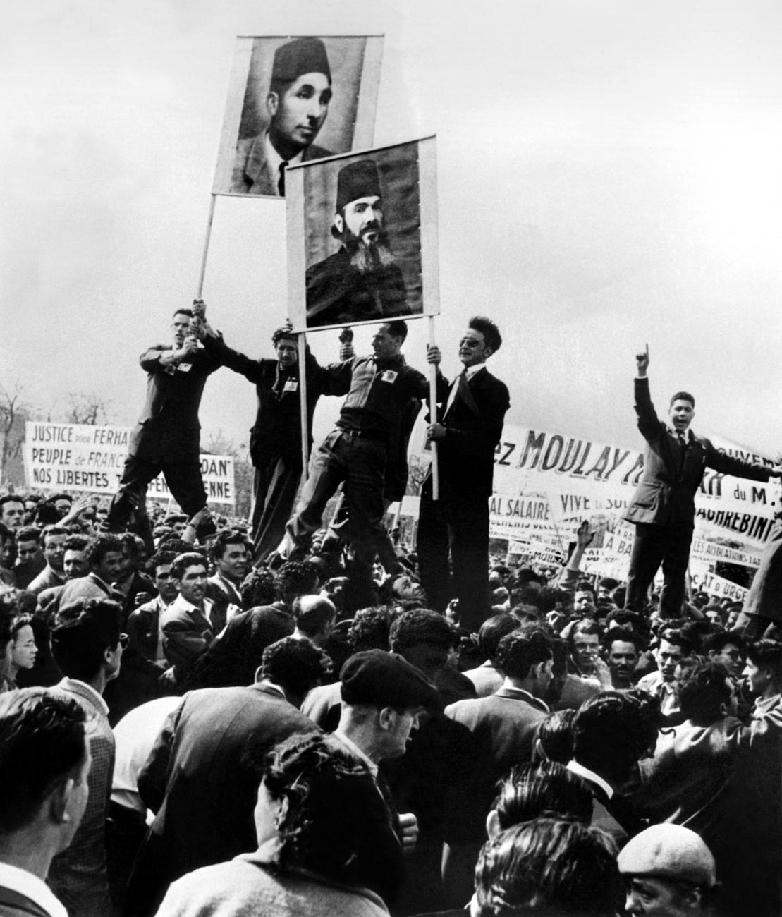 Des manifestants anticolonialistes portent des affiches de Ferhat Abbas et Messali Hadj. [Keystone/Str]