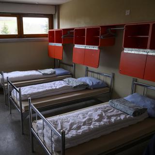 Une chambre aménagée pour les requérants d'asile, notamment ceux en provenance d'Ukraine, mardi 20 décembre 2022 à la caserne militaire de Moudon (VD). [KEYSTONE - Laurent Gillieron]