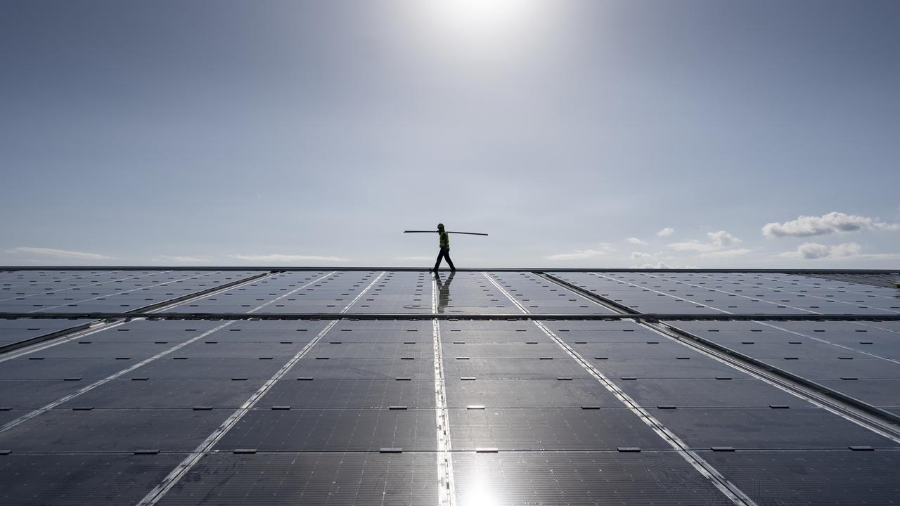 Le solaire a la cote. Ici: l'installation de panneaux photovoltaïques par un ouvrier en Valais en octobre 2022. [KEYSTONE - Gaetan Bally]