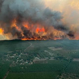 Mercredi 10 août: un mois après le début d'un gigantesque incendie dans le sud-ouest de la France, le feu a repris avec vigueur en Gironde et avait déjà dévoré mercredi 6000 hectares de forêt, provoquant l'évacuation de 8000 personnes. [Keystone - SDIS 33 Service Audiovisuel via AP]