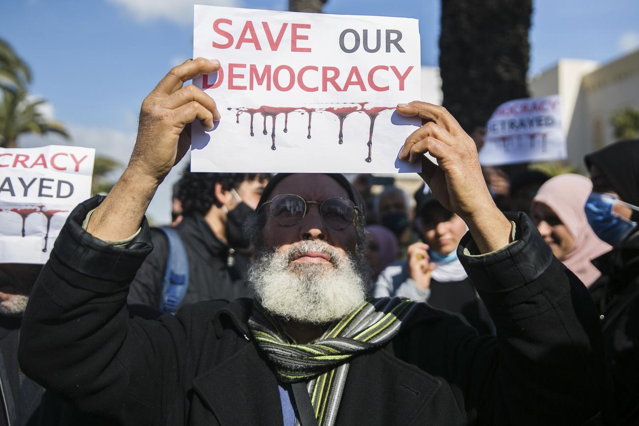 Un manifestant brandit une pancarte "Sauvez notre démocratie" lors de la manifestation à Tunis. [KEYSTONE - Hassene Dridi / AP Photo]