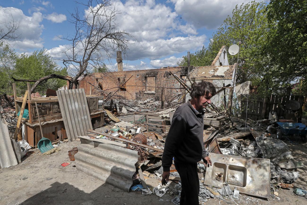 Un habitant du village de Kozarovychi montre les décombres de sa maison détruite, le 16 mai 2022. [Keystone - Sergey Dolzhenko]