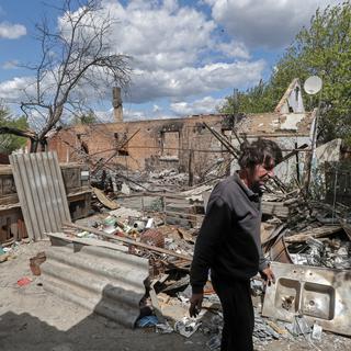 Un habitant du village de Kozarovychi montre les décombres de sa maison détruite, le 16 mai 2022. [Keystone - Sergey Dolzhenko]