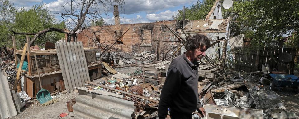 Un habitant du village de Kozarovychi montre les décombres de sa maison détruite, le 16 mai 2022. [Keystone - Sergey Dolzhenko]