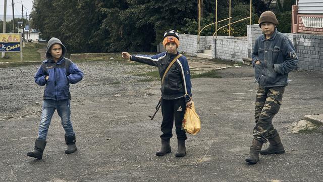 Des enfants dans les rues de Kupiansk, dans la région de Kharkiv. [Keystone - AP Photo/Kostiantyn Liberov]