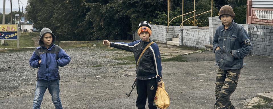 Des enfants dans les rues de Kupiansk, dans la région de Kharkiv. [Keystone - AP Photo/Kostiantyn Liberov]