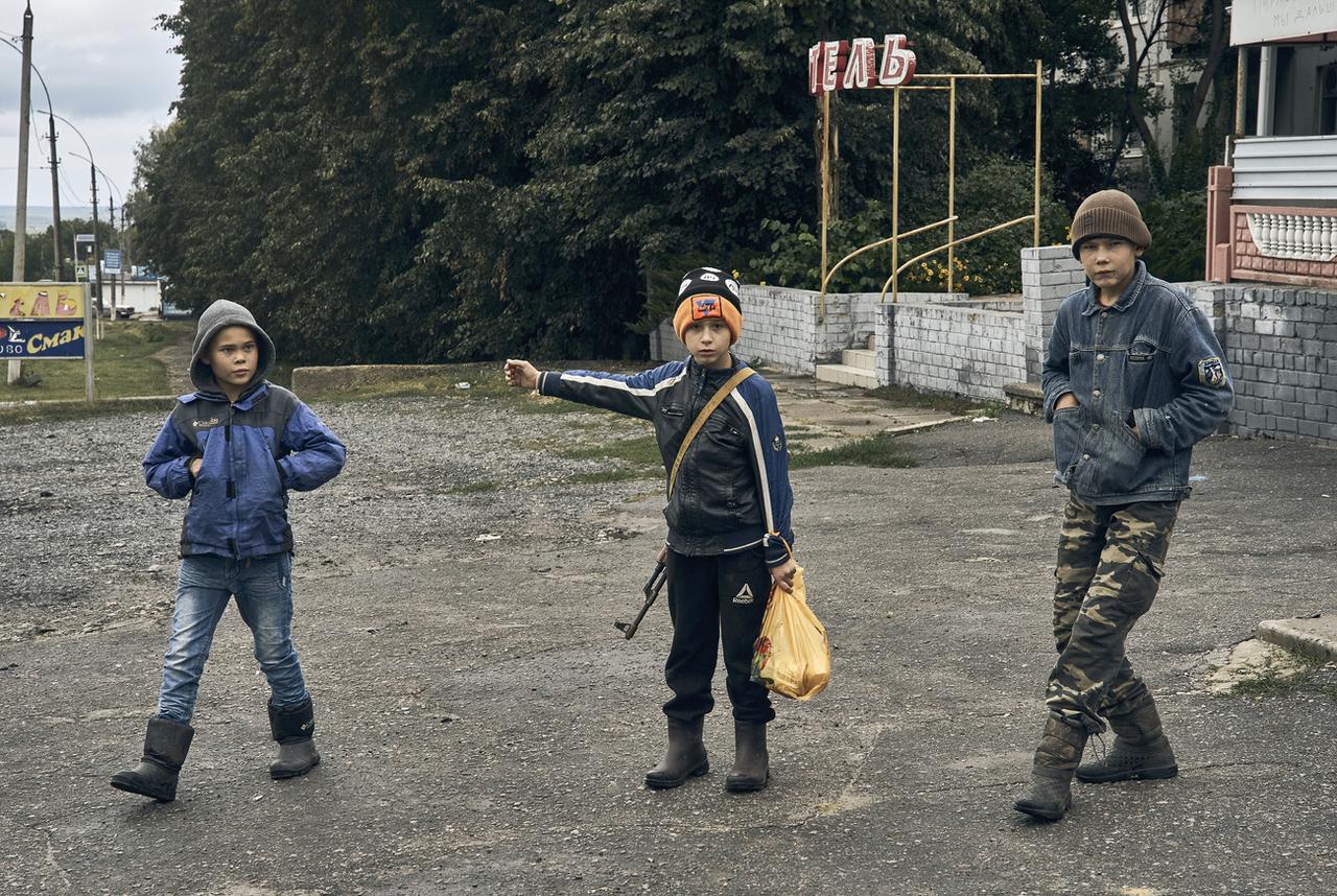 Des enfants dans les rues de Kupiansk, dans la région de Kharkiv. [Keystone - AP Photo/Kostiantyn Liberov]