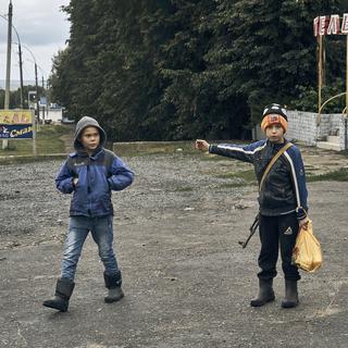 Des enfants dans les rues de Kupiansk, dans la région de Kharkiv. [Keystone - AP Photo/Kostiantyn Liberov]